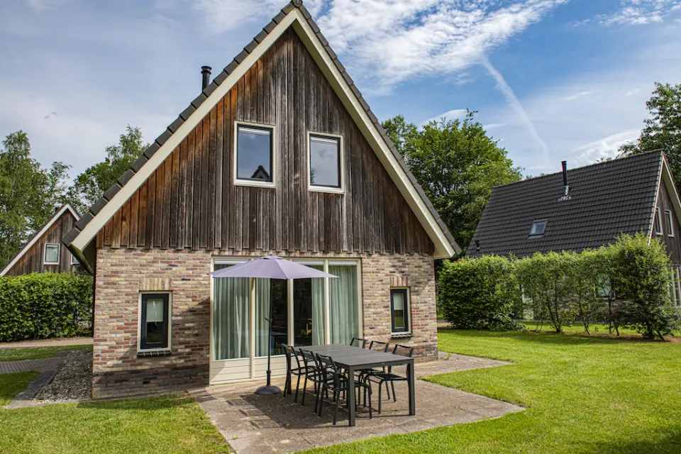 Vakantiewoning met houten puntgevel, terras met tuinset en een grasveld