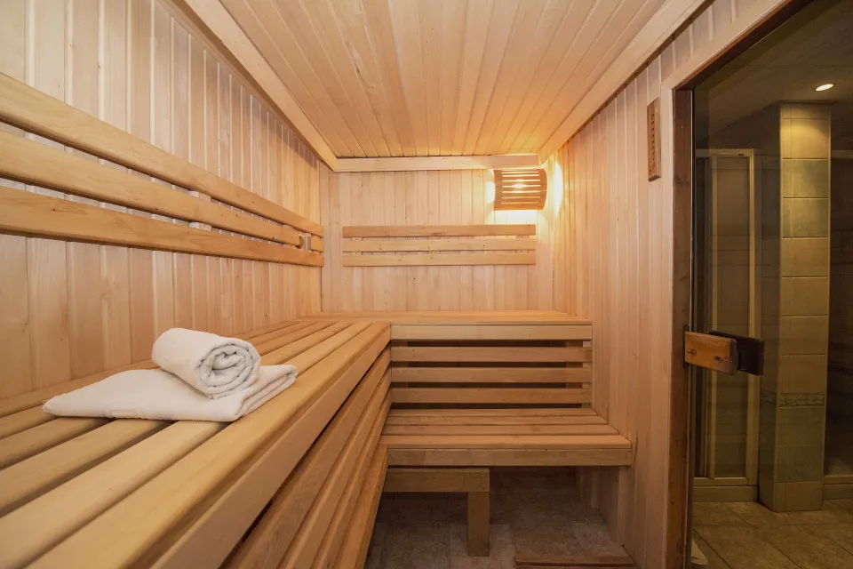Houten sauna met banken en opgerolde handdoeken