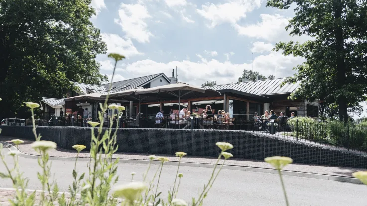 Parkrestaurant met terras gezien vanaf de weg op Bungalowpark Hoge Hexel