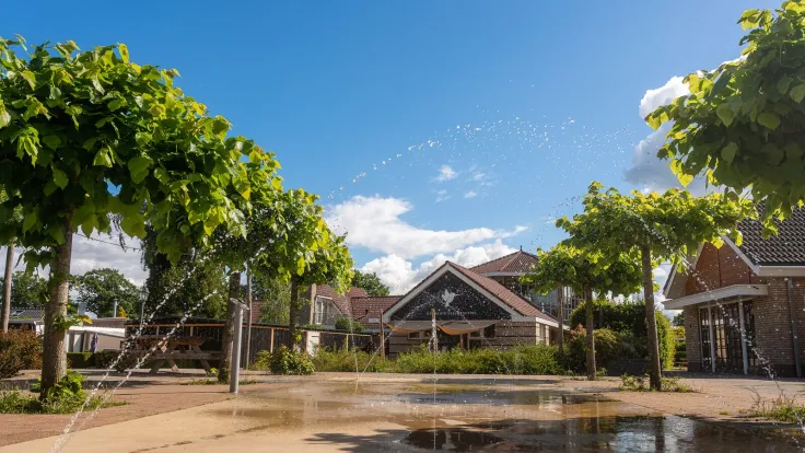 Waterspeelplaats met fonteintjes op het plein voor de parkgebouwen