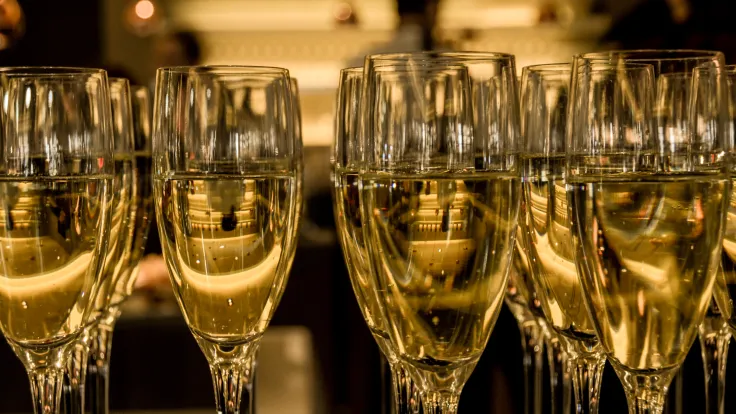 Rij gevulde champagneglazen in warm licht